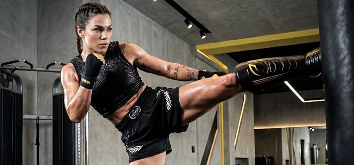 Atleta treinando chute em saco de boxe